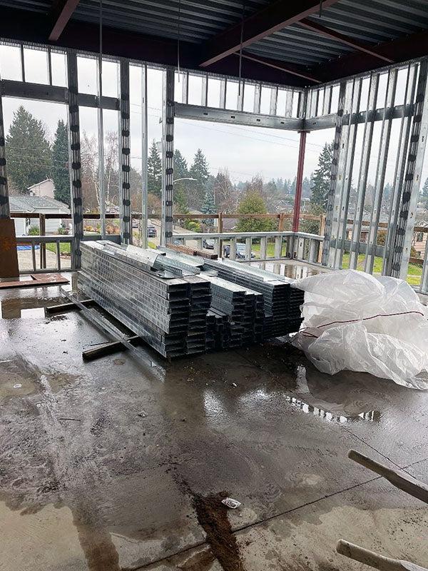 a concrete floor with a framed corner wall and a metal ceiling