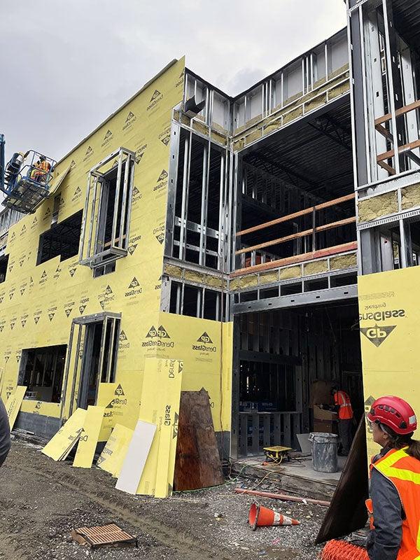 a partially built structure with yellow panels being installed