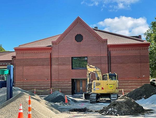 a 2-story brick building with a construction digger