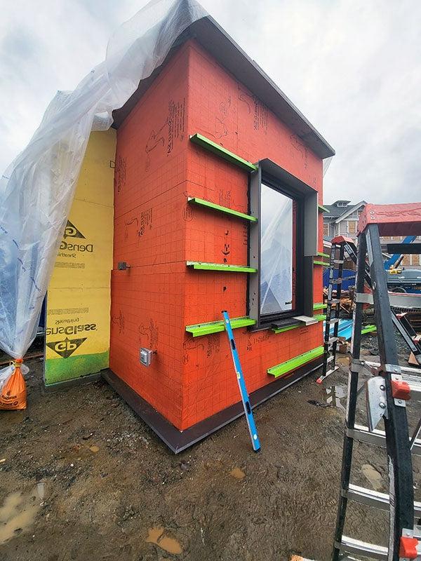 a part of a building with orange material wrapped around it