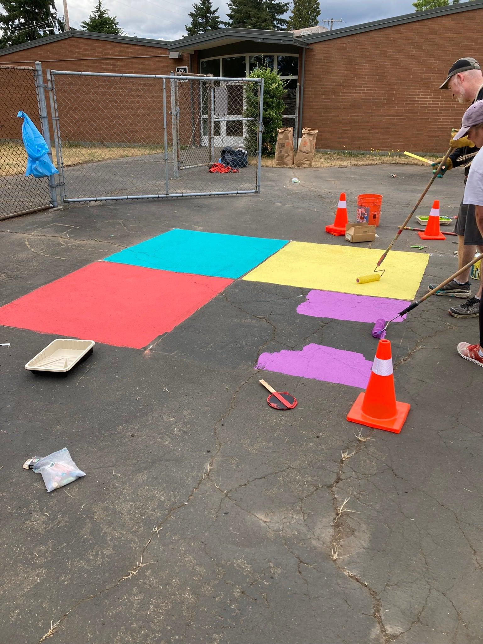 Volunteers painting four square court