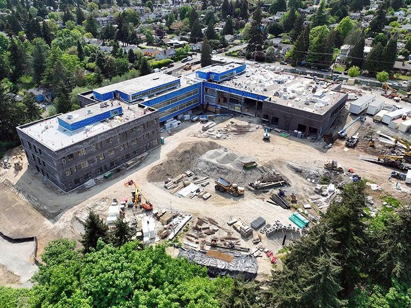 aerial of a large L shaped building with the lower right part three stories