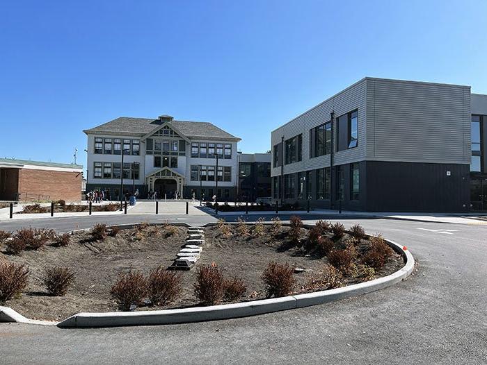 a circular driveway with two buildings in the background